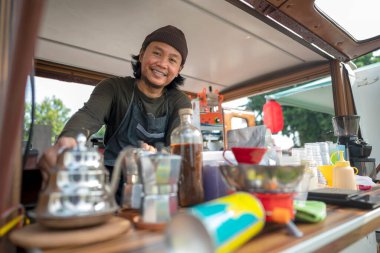 Siparişi açmadan önce Endonezyalı güneydoğu Asyalı barista kahvecisini hazırlıyor. Kamyon üzerinde küçük bir kafe ya da kafe işletmesi