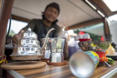 Siparişi açmadan önce Endonezyalı güneydoğu Asyalı barista kahvecisini hazırlıyor. Kamyon üzerinde küçük bir kafe ya da kafe işletmesi
