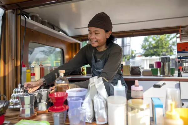 Siparişi açmadan önce Endonezyalı güneydoğu Asyalı barista kahvecisini hazırlıyor. Kamyon üzerinde küçük bir kafe ya da kafe işletmesi
