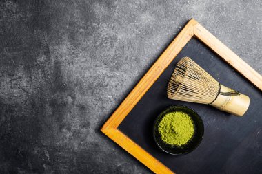 Siyah kasede kibrit yeşili çay tozu ve geleneksel bambu fırçası çırpısı ya da siyah bir masada chasen. Uyuşan yeşil çay yapmak için aksesuarlar. Uzayı kopyala Üst görünüm
