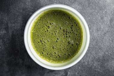 Siyah masadaki kasede bulunan yeşil çaydan daha yakın bir görüntü. Üst görünüm