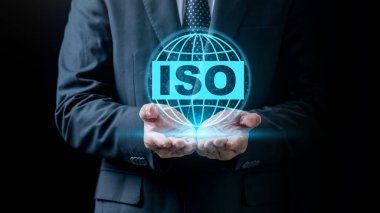 İş adamı ISO metniyle bir dünya simgesi gösteriyor. Sanal ekranda teknolojik yenilik. ISO sertifikası, küresel standartlar ve kalite güvencesi kavramı