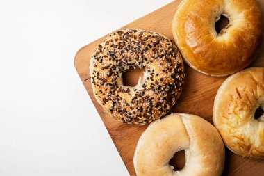 Beyaz arka planda izole edilmiş tahtadan yapılmış çeşitli tahtadan yapılmış simit ekmeklerinin yakın görüntüsü. Üst görünüm