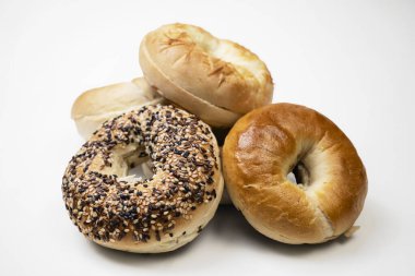 Beyaz zemin üzerinde çeşitli türde izole edilmiş simit ekmeklerinin yakın görüntüsü