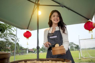 Endonezyalı güneydoğu Çinli bayan garson müşterisi için yemek hazırlıyor. Kamyonda küçük bir işletme.
