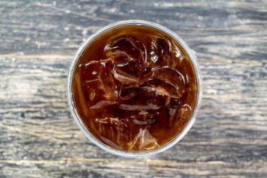 Masanın üzerinde duran soğuk kahve bardağının yakın görüntüsü. Üst görünüm