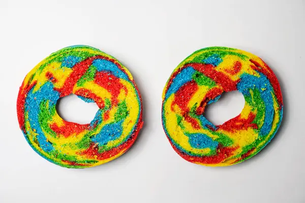 Beyaz arka planda izole edilmiş gökkuşağı simit ekmeklerinin yakın görüntüsü. Orta kısmı. Üst görünüm