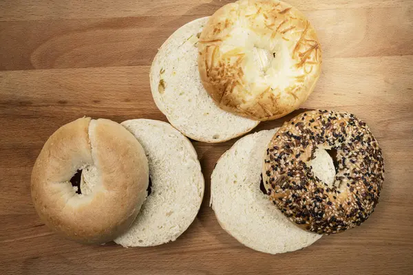 Tahta tahtanın üzerinde çeşitli şekillerde simit ekmeklerinin yakın görüntüsü. Üst görünüm