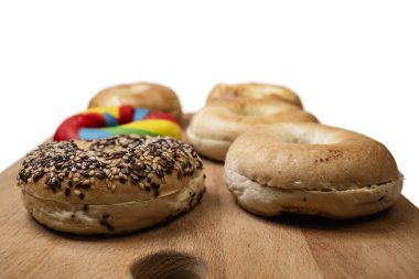 Beyaz bir arkaplan üzerine izole edilmiş tahtadan yapılmış çeşitli ekmeklerin olduğu bir simit koleksiyonunun yakın görüntüsü