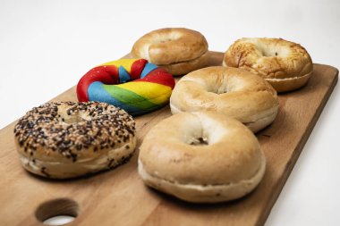 Beyaz bir arkaplan üzerine izole edilmiş tahtadan yapılmış çeşitli ekmeklerin olduğu bir simit koleksiyonunun yakın görüntüsü