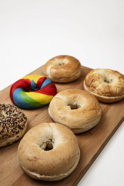 Beyaz bir arkaplan üzerine izole edilmiş tahtadan yapılmış çeşitli ekmeklerin olduğu bir simit koleksiyonunun yakın görüntüsü