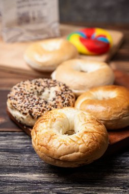 Ahşap bir tahtanın üzerinde çeşitli ekmeklerden oluşan bir simit koleksiyonunun yakın görüntüsü
