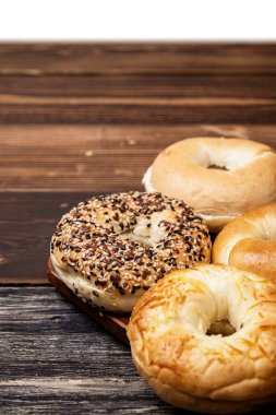 Beyaz bir arkaplan üzerine izole edilmiş tahtadan yapılmış çeşitli ekmeklerin olduğu bir simit koleksiyonunun yakın görüntüsü