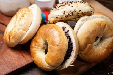 Ahşap bir tahtanın üzerinde dilimlenmiş bagel ekmeği ile çeşitli simit ekmeklerinin yakın görüntüsü