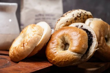 Ahşap bir tahtanın üzerinde dilimlenmiş bagel ekmeği ile çeşitli simit ekmeklerinin yakın görüntüsü