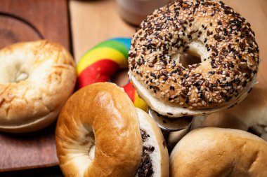 Ahşap bir tahtanın üzerinde dilimlenmiş bagel ekmeği ile çeşitli simit ekmeklerinin yakın görüntüsü