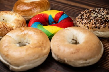 Ahşap bir tahtanın üzerinde çeşitli ekmeklerden oluşan bir simit koleksiyonunun yakın görüntüsü