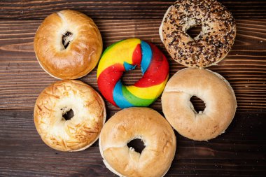 Tahta bir tahtanın üzerinde çeşitli şekillerde simit ekmeği koleksiyonu var. Üst görünüm