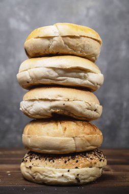 Ahşap bir tahtanın üzerinde çeşitli şekillerde simit ekmekleri olan bir yığının yakın görüntüsü