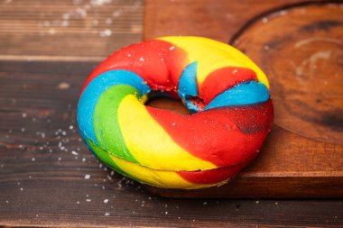 Ahşap bir tahtanın üzerinde gökkuşağı simit ekmeğinin yakın görüntüsü