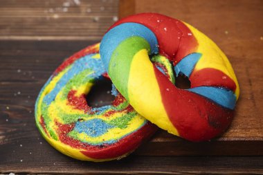 Ahşap bir tahtanın üzerinde gökkuşağı simit ekmeğinin yakın görüntüsü