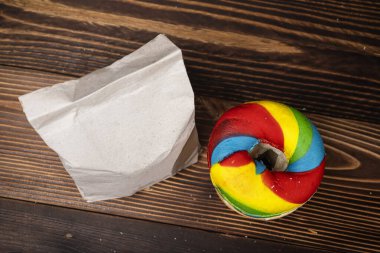 Muhtelif ekmeklerden oluşan bir yığın ve tahta bir tahtanın üzerinde kahverengi bir kese kağıdı. Üst görünüm