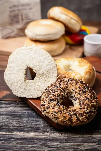 Ahşap bir tahtanın üzerinde dilimlenmiş bagel ekmeği ile çeşitli simit ekmeklerinin yakın görüntüsü