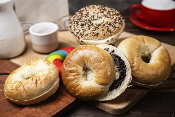 Ahşap bir tahtanın üzerinde dilimlenmiş bagel ekmeği ile çeşitli simit ekmeklerinin yakın görüntüsü