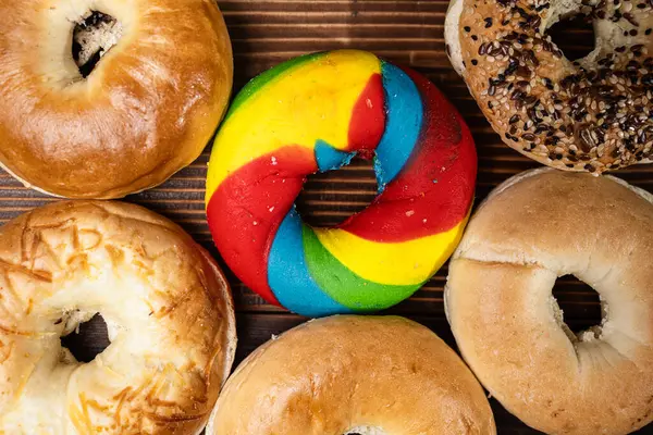 Tahta bir tahtanın üzerinde çeşitli şekillerde simit ekmeği koleksiyonu var. Üst görünüm