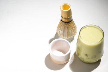 Buzlu kibrit yeşil çayın yakın görüntüsü bardakta geleneksel bambu fırçası çırpısı ile ya da beyaz arka planda chasen. Uyumlu yeşil çay yapmak için aksesuarlar.