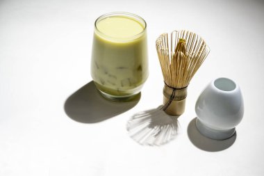 Buzlu kibrit yeşil çayın yakın görüntüsü bardakta geleneksel bambu fırçası çırpısı ile ya da beyaz arka planda chasen. Uyumlu yeşil çay yapmak için aksesuarlar.