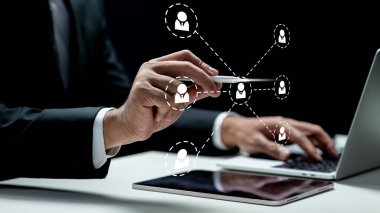 İşadamı tablet ekrandaki bağlı kişi simgesine dokunurken bir dizüstü bilgisayar kullanıyor. Sanal ekranda teknolojik yenilik. Halkla ilişkiler kavramı