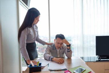 Endonezyalı güneydoğu Asyalı işadamı geç kaldığı için ya da teslim tarihlerinin stresi yüzünden patronundan tavsiye alır. Cep telefonu ve evraklar masada. İş konsepti