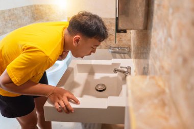 Endonezyalı güneydoğu Asyalı adam kusmak istiyor, hasta ve hasta hissediyor, çok fazla sağlıksız abur cubur yiyor veya gıda zehirlenmesi geçiriyor. Sağlık hizmetleri kavramı