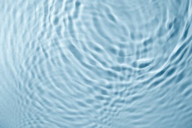 Mavi su dokusu arka planı. Yüzükler ve dalgalanmalarla şeffaf su yüzeyi. Yaz kavramı. Düz yatıyordu