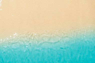 Güzel kumlu bir sahilde temiz ve şeffaf mavi okyanus dalgaları. Doğal arka plan. Yaz konsepti