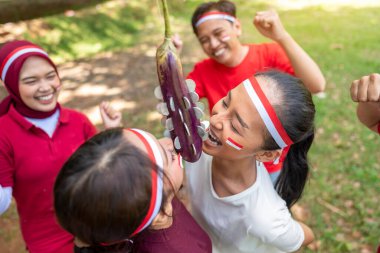 Endonezya 'nın güneydoğu Asya halkının portresi Endonezya Bağımsızlık Günü' nü 17 Ağustos 'ta açık havada patlıcanlarda para ısırma oyunuyla kutluyor. Kemerdekaan Endonezya kavramı