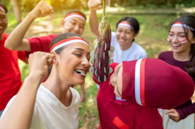 Endonezya 'nın güneydoğu Asya halkının portresi Endonezya Bağımsızlık Günü' nü 17 Ağustos 'ta açık havada patlıcanlarda para ısırma oyunuyla kutluyor. Kemerdekaan Endonezya kavramı