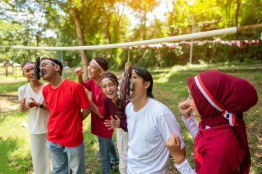 Endonezya 'nın güneydoğu Asya halkının portresi Endonezya Bağımsızlık Günü' nü 17 Ağustos 'ta açık havada patlıcanlarda para ısırma oyunuyla kutluyor. Kemerdekaan Endonezya kavramı