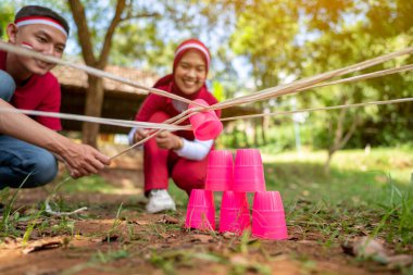 Endonezya 'nın güneydoğusundaki Asyalıların portresi Endonezya Bağımsızlık Günü' nü 17 Ağustos 'ta dışarıda bir çubukla plastik cam yığını inşa etme oyunuyla kutluyor. Kemerdekaan Endonezya kavramı