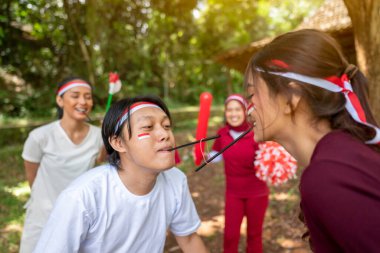 Endonezya 'nın güneydoğu Asya halkının portresi Endonezya Bağımsızlık Günü' nü 17 Ağustos 'ta dışarıda pipetle lastik bant taşıma oyunuyla kutluyor. Kemerdekaan Endonezya kavramı
