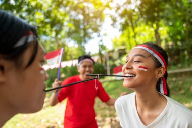 Endonezya 'nın güneydoğu Asya halkının portresi Endonezya Bağımsızlık Günü' nü 17 Ağustos 'ta dışarıda pipetle lastik bant taşıma oyunuyla kutluyor. Kemerdekaan Endonezya kavramı