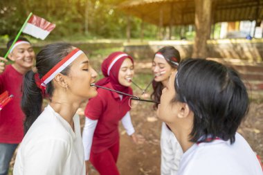 Endonezya 'nın güneydoğu Asya halkının portresi Endonezya Bağımsızlık Günü' nü 17 Ağustos 'ta dışarıda pipetle lastik bant taşıma oyunuyla kutluyor. Kemerdekaan Endonezya kavramı