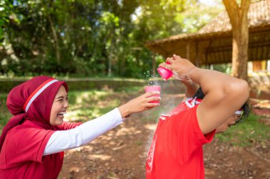 Endonezya 'nın güneydoğu Asya halkının portresi Endonezya Bağımsızlık Günü' nü 17 Ağustos 'ta dışarıda plastik bardaklarla un taşıyarak kutluyor. Kemerdekaan Endonezya kavramı
