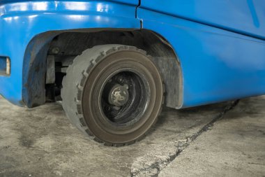 Depo binasının içindeki beton bir kattaki forkliftin yakın görüntüsü. Depolama, envanter, endüstri ve lojistik