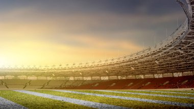 Arka planda günbatımı sahnesi olan bir Amerikan futbol stadyumunun bahçesinde.