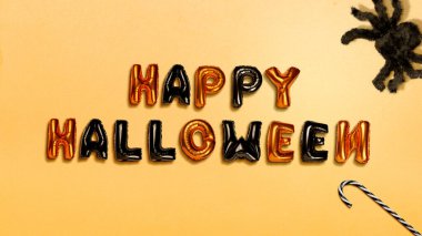 Renkli arka planda örümcekle Mutlu Cadılar Bayramı metni olan renkli bir balon. Mutlu Cadılar Bayramı kavramı