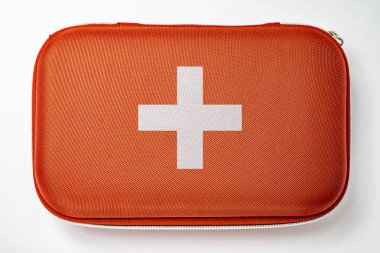 Beyaz arka planda izole edilmiş kırmızı bir ilk yardım çantasının yakın görüntüsü. İlk yardım çantası kavramı