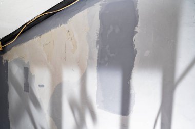 Ev tadilatı sırasında bitmemiş gri bir duvarın yakın görüntüsü. Ev yenileme projesi