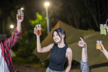 Endonezyalı güneydoğu Asyalı bir grup kadın açık havada dinleniyor ve serinletici içeceklerin tadını çıkarıyor. Doğal ortamdaki yemekten zevk alma sahnesi.